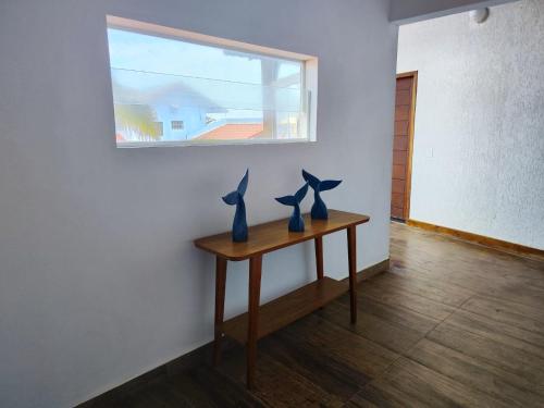 two vases on a table in a room with a window at Toya Hotel in Ilha Comprida