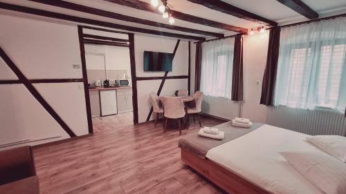 a bedroom with a bed and a table with chairs at Lindenhaus in Sibiu