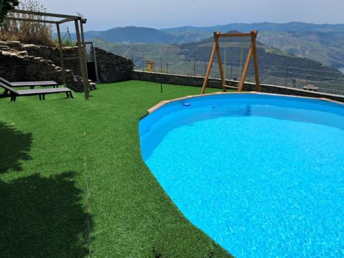 a blue swimming pool with a bench and a view at Riba Loivos Village - Casa C - T3 in Casal de Loivos