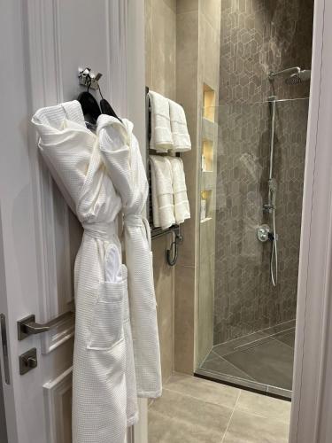 La salle de bains est pourvue d'une douche et de serviettes blanches sur une porte. dans l'établissement Apartments in the heart of Cannes, à Cannes