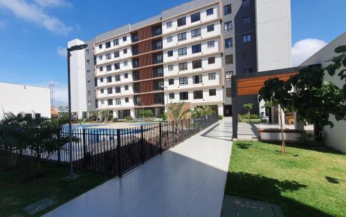 a building with a fence and a swimming pool at Apto condomínio conforto e ótima localização in Lucas do Rio Verde