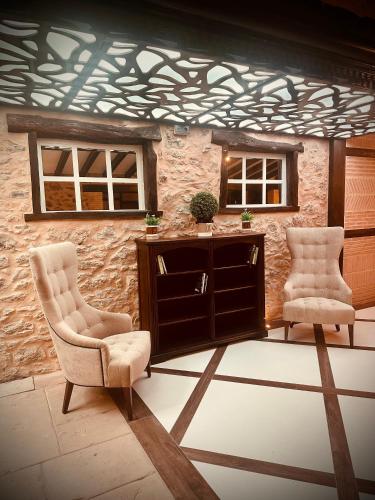 two chairs and a cabinet in front of a wall at La Quinta Luxury Palace in Arnuero
