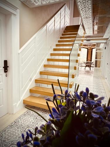 a staircase in a house with purple flowers in the foreground at La Quinta Luxury Palace in Arnuero