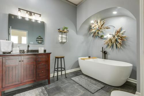 a bathroom with a tub and a sink and a mirror at Sprawling Kentucky Getaway with Pool and Hot Tub! in Berry