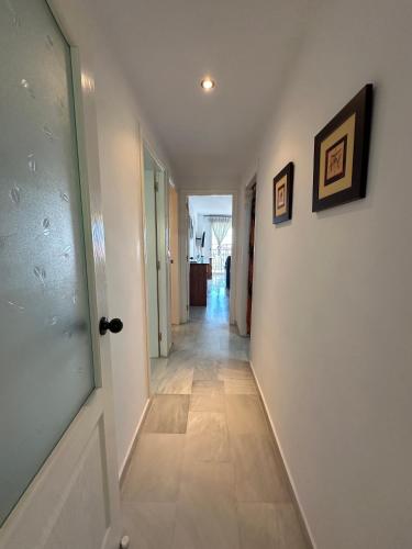 a hallway with white walls and a door and a tile floor at Precioso apartamento en la Herradadura in La Herradura