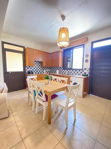 a kitchen with a dining room table and chairs at Pervolina countryside by the sea in Pervolia