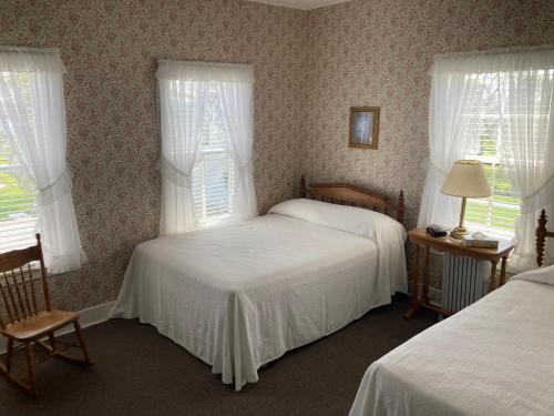 a bedroom with two beds and two windows at Shaw's Hotel & Cottages in Brackley Beach
