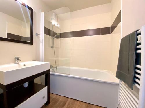 une salle de bain avec un lavabo et une baignoire et un lavabo dans l'établissement La villa Astrid - 2 chambres - piscine - mer - parking, au Crotoy