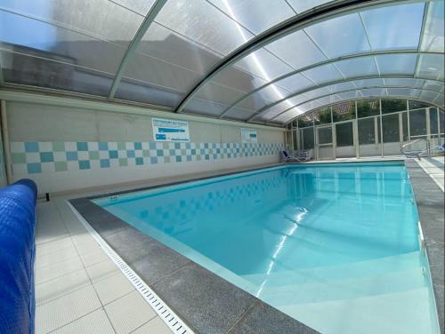 une grande piscine avec un plafond de verre dans l'établissement La villa Astrid - 2 chambres - piscine - mer - parking, au Crotoy