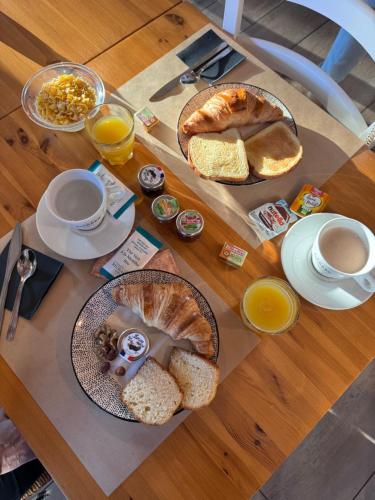 a table with bread and coffee and two plates of food at The Originals City, Hôtel Le Lodge, Ondres, Bayonne Nord in Ondres