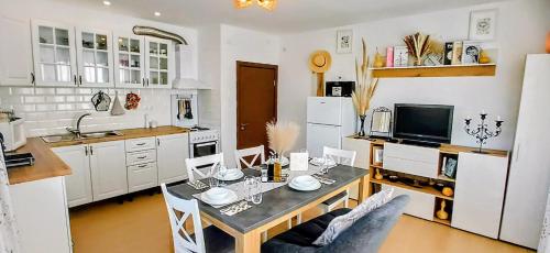 a kitchen with a dining table and a kitchen with white cabinets at Къща за гости Веселина - Ивайловград in Ivaylovgrad