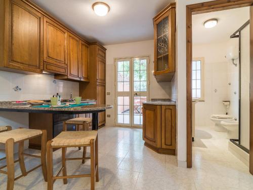 Una cocina con gabinetes de madera y encimera. en Villa il Carrubo, en Cala Gonone