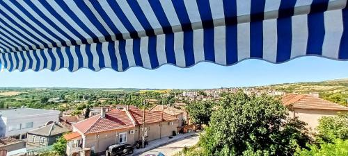 a blue and white umbrella with a view of a city at Къща за гости Веселина - Ивайловград in Ivaylovgrad
