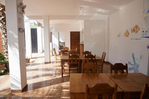 a dining room with wooden tables and chairs at Akumal Hotel in Máncora