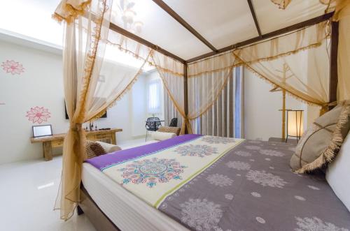 1 dormitorio con cama con dosel en una habitación en Happy House Homestay, en Hualien City