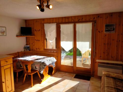 d'une salle à manger avec une table et une porte coulissante en verre. dans l'établissement SAMOENS appartement proche du centre, à Samoëns