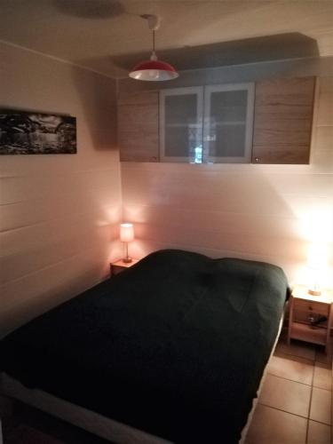 - une chambre avec un lit et deux lumières sur deux tables dans l'établissement SAMOENS appartement proche du centre, à Samoëns