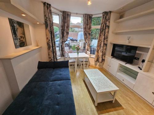 a living room with a couch and a table at Cosy Apartment in North London - Great Location in London
