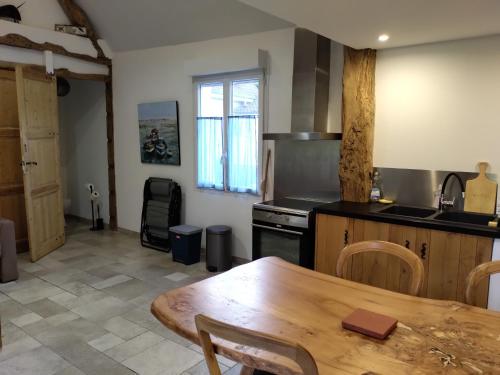 - une cuisine équipée d'une table, d'une cuisinière et d'un sidx de table dans l'établissement Gîte à la ferme, à Mons-Boubert