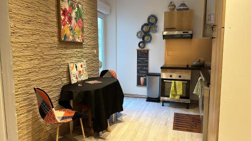une cuisine avec une table et des chaises dans une pièce dans l'établissement Au Kouka home, à Cannes