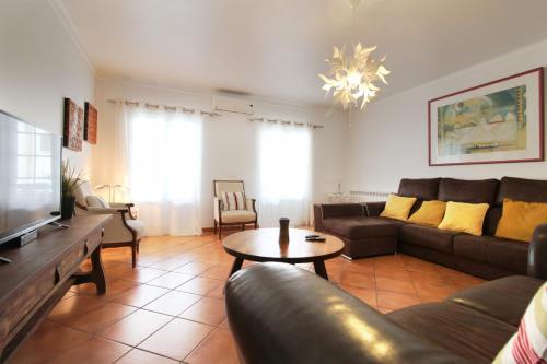 ein Wohnzimmer mit Sofa und Tisch in der Unterkunft Casa Macau T4 com piscina in Pousadas