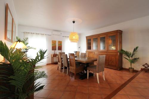 ein Esszimmer mit Tisch und Stühlen in der Unterkunft Casa Macau T4 com piscina in Pousadas