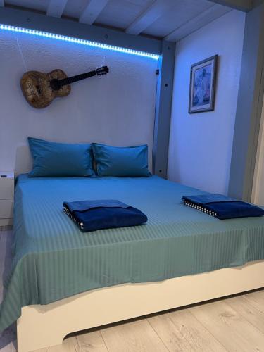 - une chambre avec un lit et une guitare sur le mur dans l'établissement Appartement en Rez-de-jardin, à Nice
