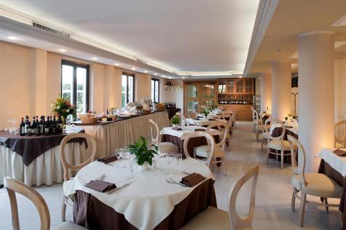 een restaurant met tafels en stoelen met wijnflessen bij Grand Hotel Bonanno in Pisa