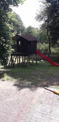 a playground with a red slide in a park at Zajazd Stok in Górecko Stare