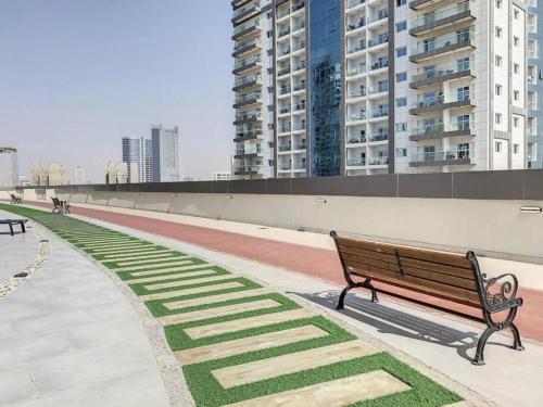a park bench in a city with tall buildings at Stylish Studio Urban Retreat in Dubai