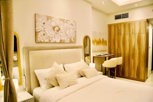 a bedroom with a large white bed and a desk at Stylish Studio Urban Retreat in Dubai
