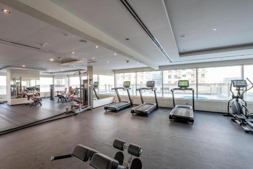 a gym with cardio equipment in a large room at Stylish Studio Urban Retreat in Dubai