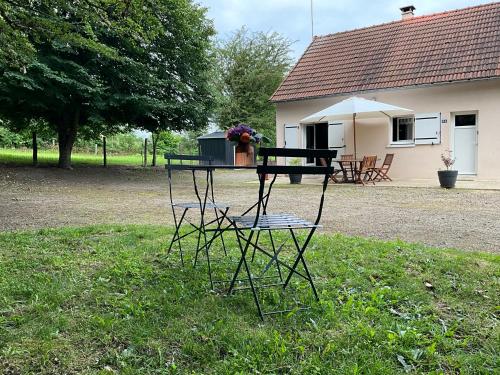 a table and chair in a yard with a house at La petite vallée in Crozant