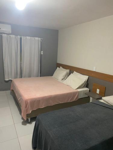 a bedroom with two beds and a window in it at Pousada Tambaú in João Pessoa