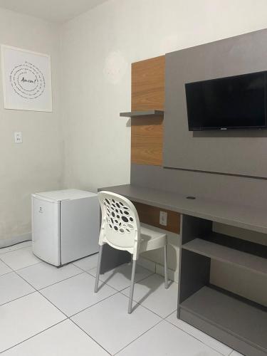 a desk with a tv and a chair in a room at Pousada Tambaú in João Pessoa