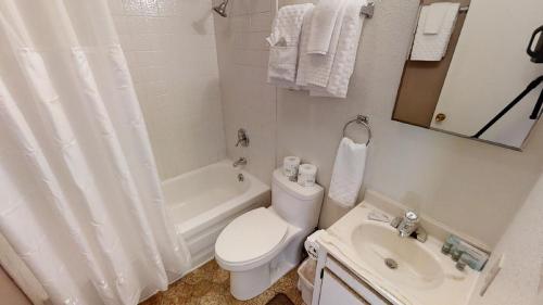a white bathroom with a toilet and a sink at Mountain View 3 - Grill - WiFi - Mountain Views - Washer - Dryer - Garage Access - Walk to Everything in Red River