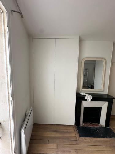 Cette chambre comprend un placard blanc et un miroir. dans l'établissement Il grand maison, à Argenteuil