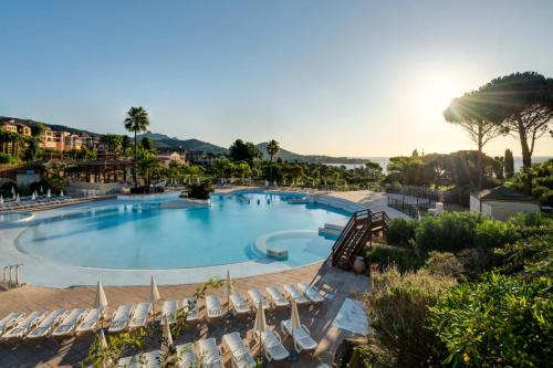 une grande piscine avec des chaises longues dans un complexe dans l'établissement Résidence le Hameau de Cap Esterel - maeva Home - Appartement 3 pièces 7 personnes avec vue mer - Prestige MAE-6934, à Saint-Raphaël