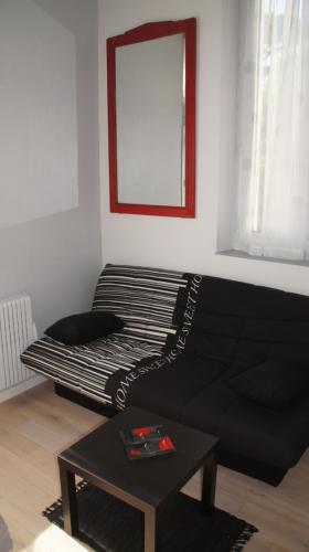 - un salon avec un canapé noir et un miroir dans l'établissement Villa Rosa, à Pornichet