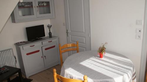 une salle à manger avec une table et une télévision dans l'établissement Villa Rosa, à Pornichet