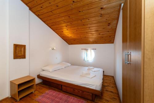 Un dormitorio con una cama con techo de madera. en Dodo Sea View Apartments, en Novalja
