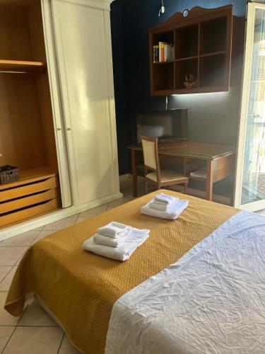 a bedroom with a bed with two towels on it at Specter Guesthouse in Nettuno
