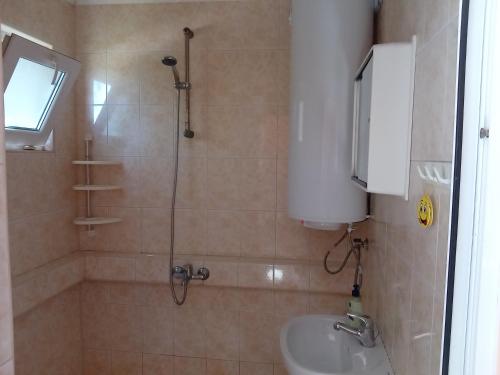 a bathroom with a shower and a toilet and a sink at Къща бунгало Градината in Krapets