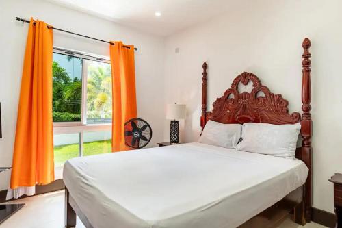 1 dormitorio con 1 cama grande y cortina de color naranja en Apt - Gated Community-Sleeps 4-Balcony-Parking, en Runaway Bay