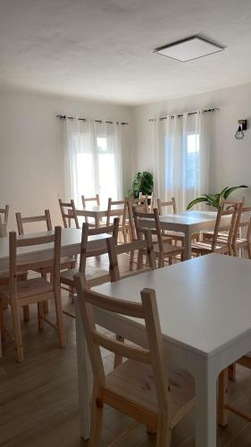 a dining room with tables and chairs and windows at L'Oro Verde in Moricone