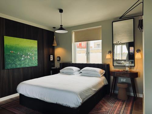 ein Schlafzimmer mit einem Bett mit weißer Bettwäsche und einem Fenster in der Unterkunft Stunning Designer House, Fantastic City Location - Cambridge Homehost in Cambridge