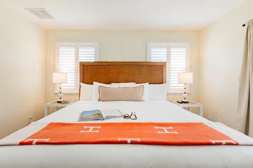 a bedroom with a bed with a book on it at The Beach Club on Madison Avenue in Cape May