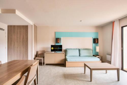 un salon avec un lit et une table dans l'établissement Résidence L'Archipel - maeva Home - Appartement vue mer 3 pièces 6 personnes - Prestige MAE-6251, à Perros-Guirec