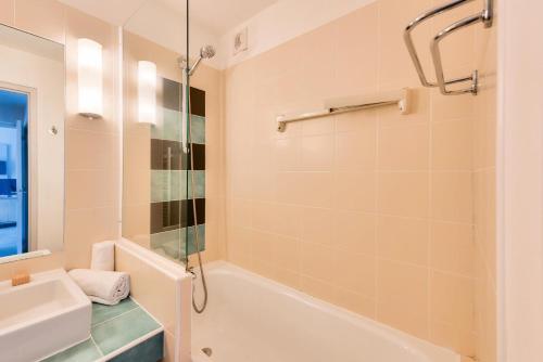 une salle de bain avec une baignoire, un lavabo et une douche dans l'établissement Résidence L'Archipel - maeva Home - Appartement vue mer 3 pièces 6 personnes - Prestige MAE-6251, à Perros-Guirec
