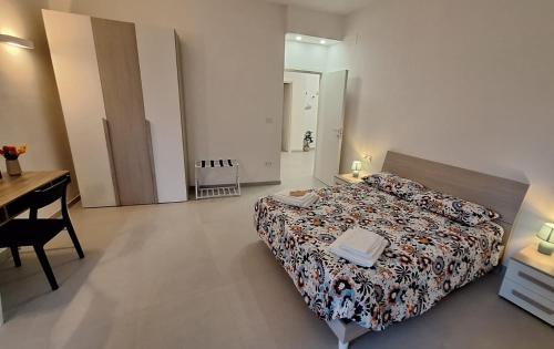 a bedroom with a bed and a table and a desk at Lettera 22 Apartment in Brindisi